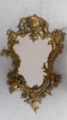 A Rococo style ormolu gilt brass mirror. Rocaille formed frame with wooden back. H.80xW.51cm