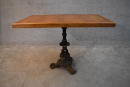 An oak topped conservatory table with cast iron pedestal base formed of entwined dolphins. H.