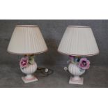 A pair of relief hand painted ceramic urn and flower table lamps on square bases. H.65x45cm