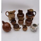 A collection of antique earthenware jugs and teapots and a hand painted porcelain oriental teapot.