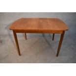 A mid 20th century vintage teak extending dining table with swivel leaves fitted to the underside.