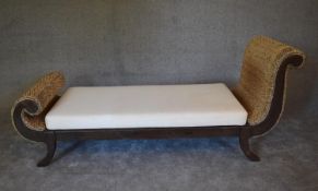 A large teak framed rattan chaise longue with cream calico squab cushion. H.85 x 195 x 70cm