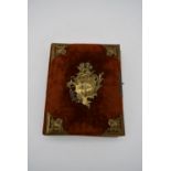 A Victorian velvet covered photo album with repousse brass rococo style cartouche and bindings. H.
