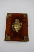 A Victorian velvet covered photo album with repousse brass rococo style cartouche and bindings. H.