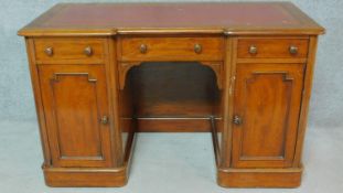 A Victorian mahogany kneehole desk with red leather top, on plinth base with casters. H.76 W.122 D.