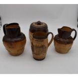 An antique Royal Doulton tobacco jar along with three antique salt glaze earthenware jugs. H.25cm