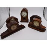 An Edwardian mahogany and satinwood inlaid lancet mantel clock and four other Edwardian mantel