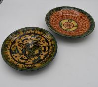 Two antique persian hand painted glazed ceramic dishes. One with a Persian deity surrounded by