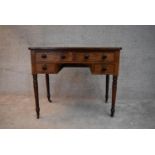 A 19th century mahogany writing table fitted with an arrangement of drawers on turned tapering