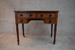 A 19th century mahogany writing table fitted with an arrangement of drawers on turned tapering