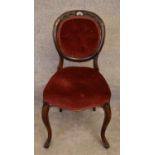 A Victorian mahogany framed balloon backed armchair on carved cabriole supports. H.85x43cm