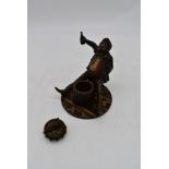 An antique cold painted bronze ink well in the form of a drunk man with a bottle of beer sitting