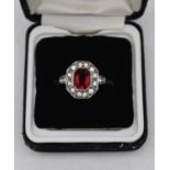 A vintage 9ct gold and silver cluster ring, set to centre with an emerald cut red paste stone
