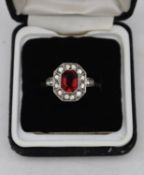 A vintage 9ct gold and silver cluster ring, set to centre with an emerald cut red paste stone