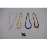 A collection of vintage Czech glass necklaces including an opaque yellow and white glass necklace, a