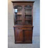 A Victorian mahogany two section library bookcase with arched glazed panel doors above base fitted