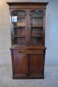 A Victorian mahogany two section library bookcase with arched glazed panel doors above base fitted