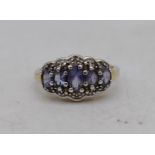 A silver and tanzanite and white stone five stone cocktail ring. Set with five oval mixed cut