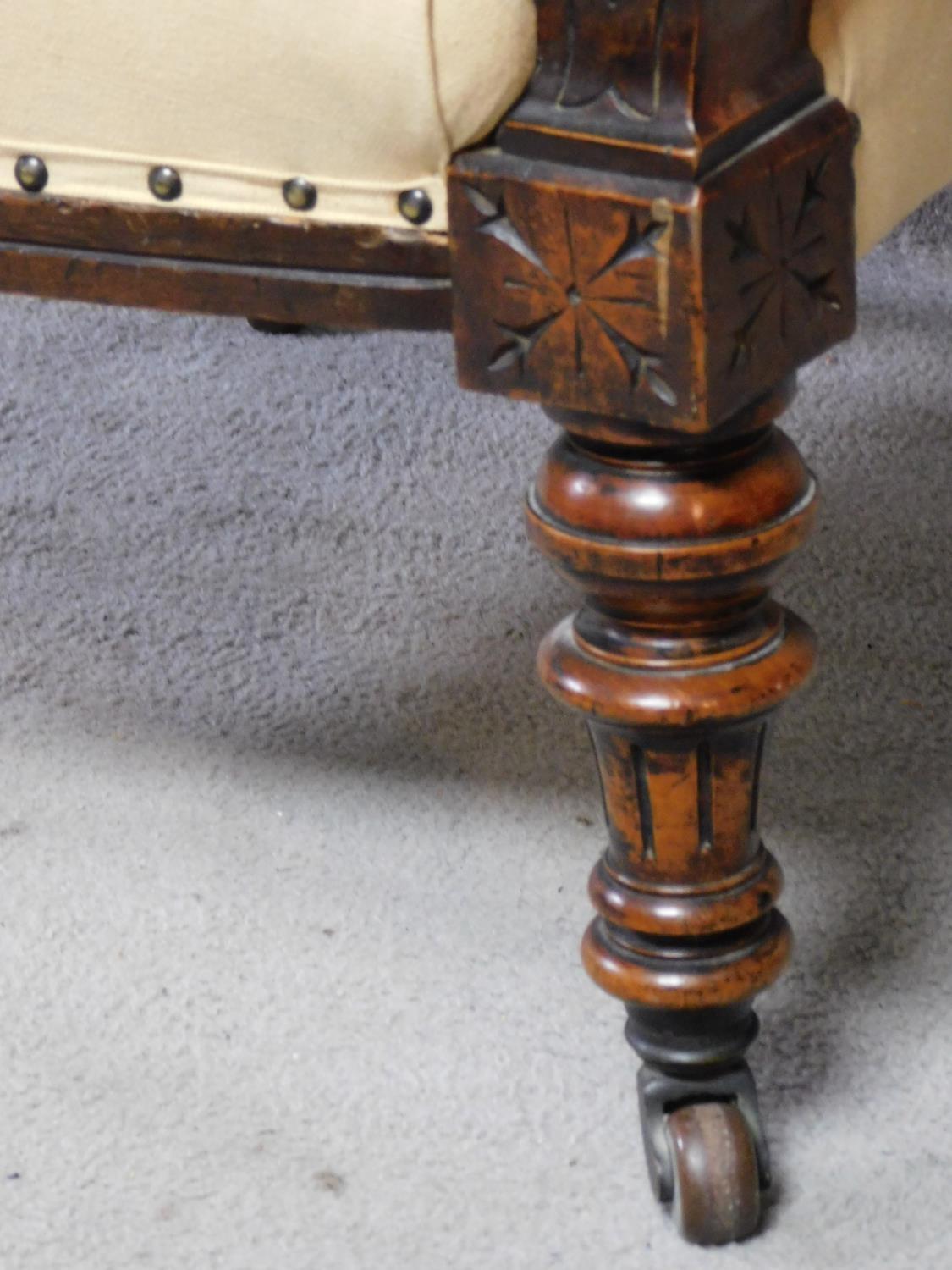 A late Victorian carved walnut armchair on turned tapering supports terminating in ceramic - Image 5 of 5