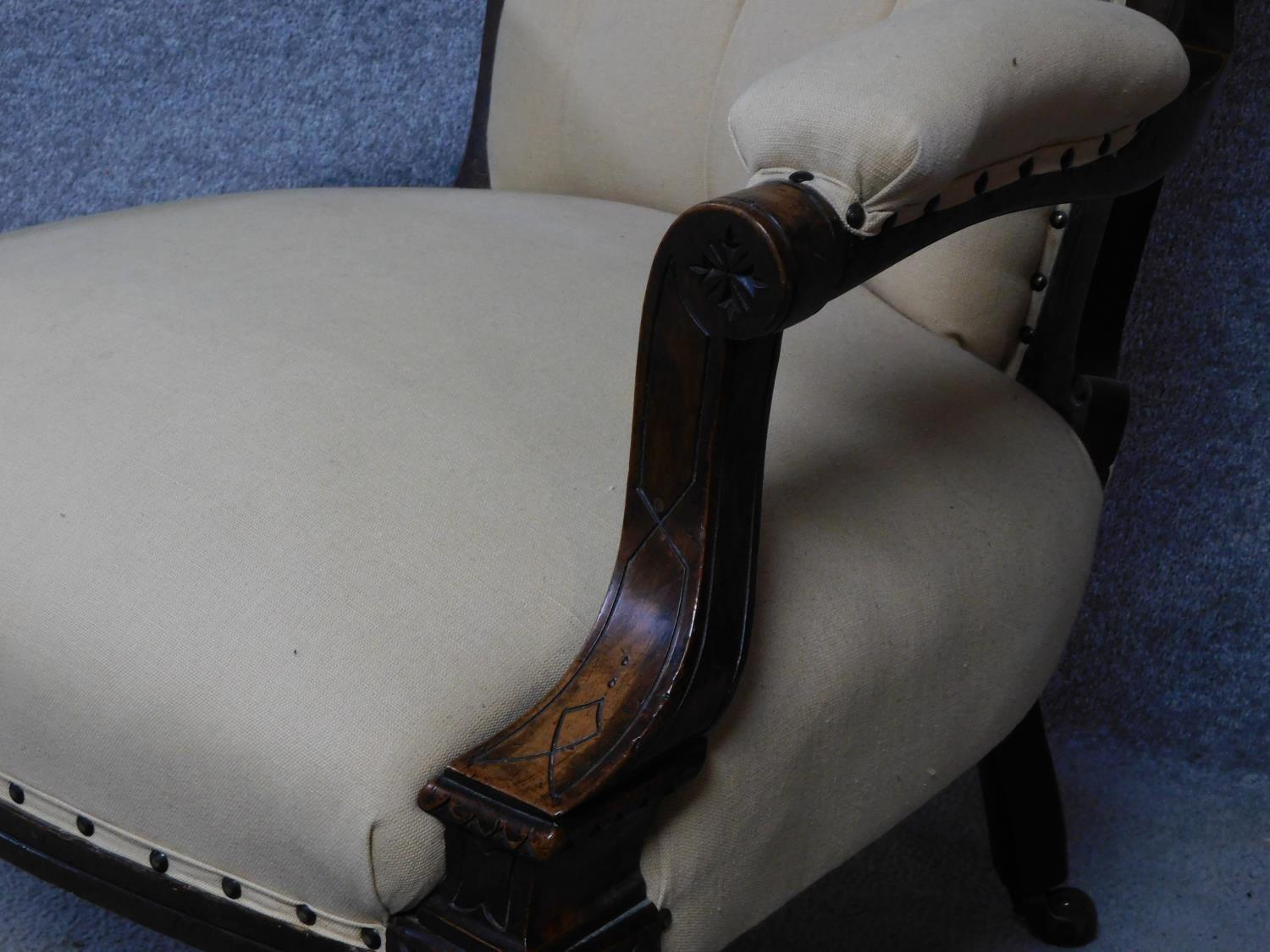 A late Victorian carved walnut armchair on turned tapering supports terminating in ceramic - Image 4 of 5