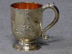 A Corbell and Co silver plated and gilded tankard with repousse floral design and scrolling