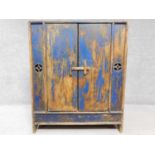 An Eastern distressed painted hardwood pantry cupboard with panel doors enclosing shelves. H.99 W.82