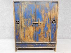 An Eastern distressed painted hardwood pantry cupboard with panel doors enclosing shelves. H.99 W.82