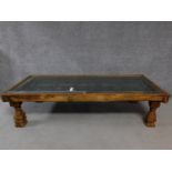 An antique Indian hardwood carved door converted to low coffee table with glazed top raised on