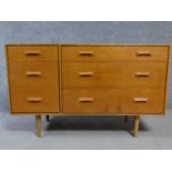 A 1970's vintage teak chest of three graduating long drawers flanked by three short drawers raised
