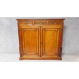 A 19th century mahogany press cupboard with three frieze drawers over panel doors enclosing linen