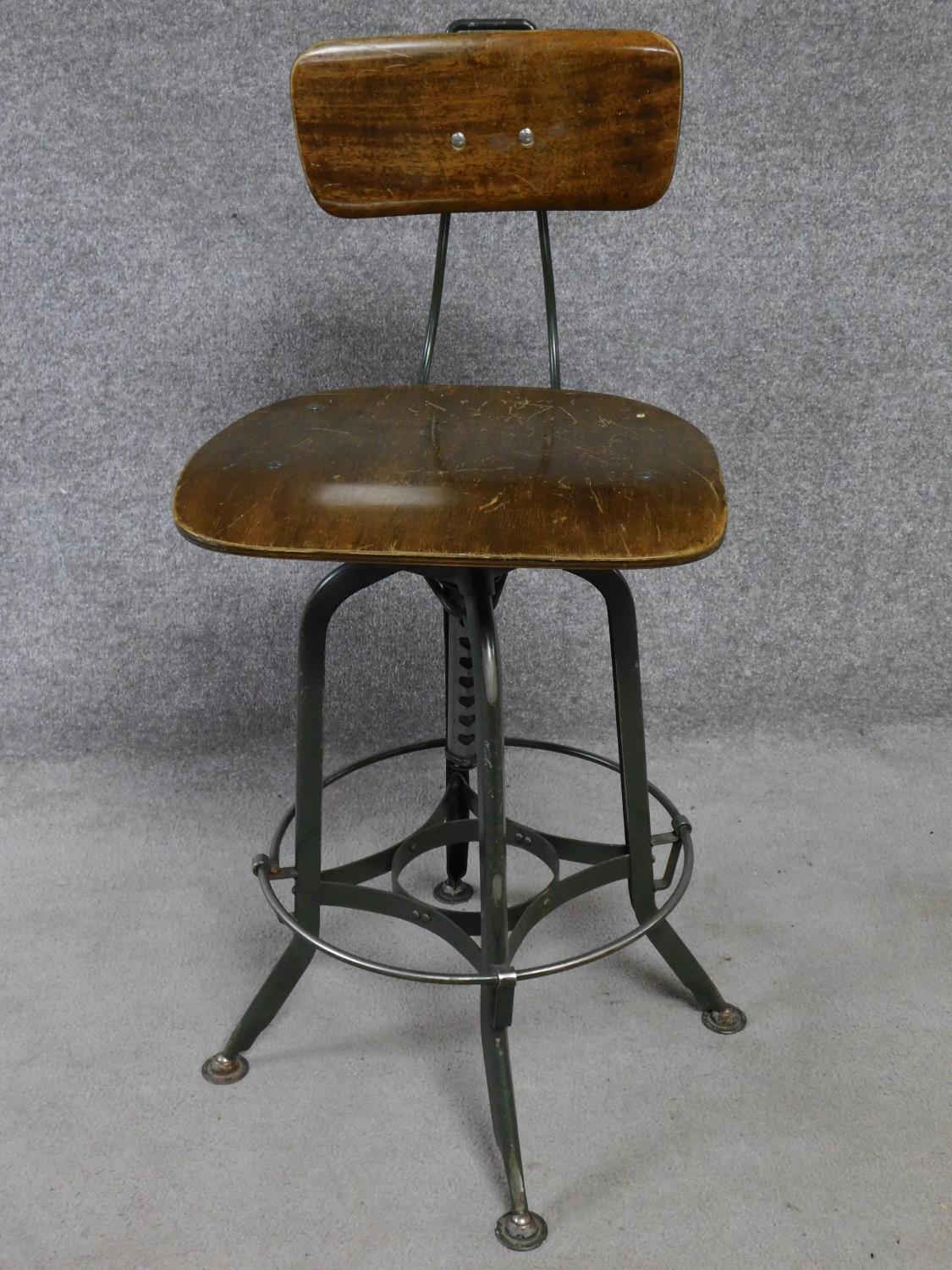 A mid 20th century industrial style metal framed machinist's chair with laminated seat and back. H.