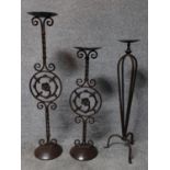 A pair of wrought iron floor standing pricket candlesticks together with a similar one. H.94cm (