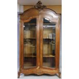 A late 19th century or early 20th century French well carved walnut armoire with glazed panel