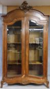 A late 19th century or early 20th century French well carved walnut armoire with glazed panel