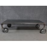 An industrial style aluminium coffee table on large trolley wheels. H.41 W.158 D.62cm