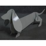 A metal painted sculpture of a sausage dog by British artist Peter Clark. 32x80cm
