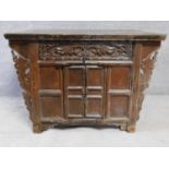 An Eastern carved teak side cabinet fitted with central panel door. H.83 W.120 D.87cm