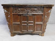 An Eastern carved teak side cabinet fitted with central panel door. H.83 W.120 D.87cm
