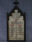 A late 19th century carved oak Gothic style board with crucifix motif painted with a list of