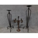 A wrought iron floor standing pricket candlestick, another similar and a table candelabra. H.78cm