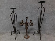 A wrought iron floor standing pricket candlestick, another similar and a table candelabra. H.78cm
