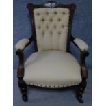 A late Victorian carved walnut armchair on turned tapering supports terminating in ceramic