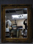 A gilt framed rococo style wall mirror with bevelled plate. 158x128cm