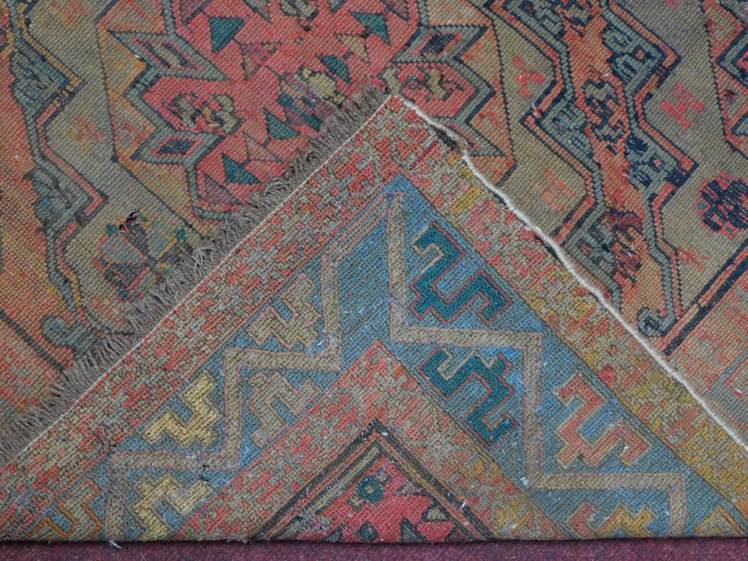 A Persian rug with repeating multicolour diamond motifs surrounded by repeating geometric borders - Image 4 of 6