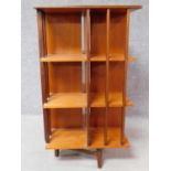 A 1970s vintage teak revolving bookcase on square stretchered supports. H.109 W.61 D.61cm