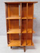 A 1970s vintage teak revolving bookcase on square stretchered supports. H.109 W.61 D.61cm