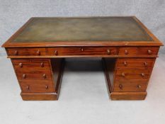 A 19th century mahogany pedestal desk with inset green tooled leather top and an arrangement of nine