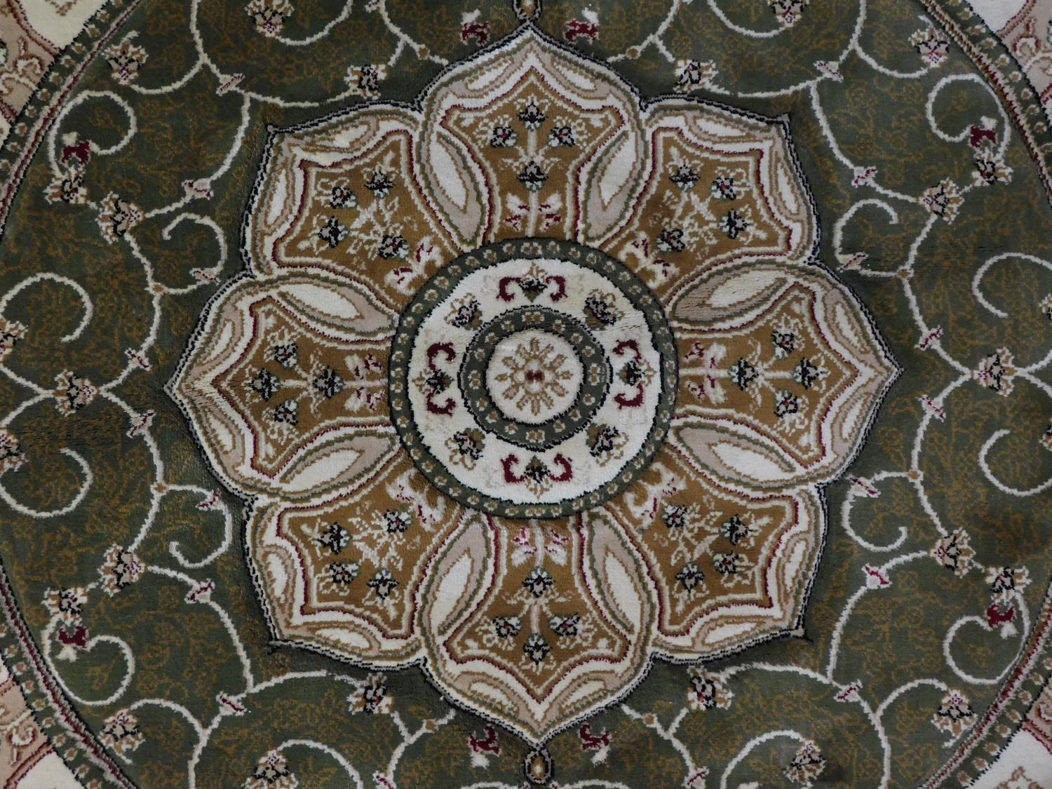 A circular Eastern rug with central pendant medallion on a green and ivory field 150x150cm - Image 2 of 5