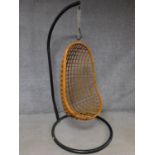 A vintage bamboo hanging egg shaped chair supported on black metal frame. H.181cm