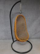 A vintage bamboo hanging egg shaped chair supported on black metal frame. H.181cm